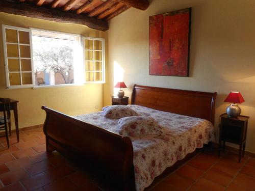 een slaapkamer met een bed en een raam bij Le Mas des Vignes in Bandol