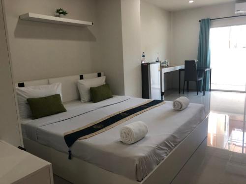 a bedroom with a large bed with two pillows on it at Khao Oat airport in Nai Yang Beach