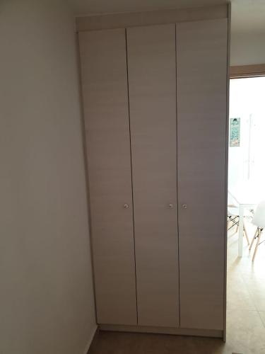 a room with white cabinets and a white wall at Maya Apartments in Dexamenes
