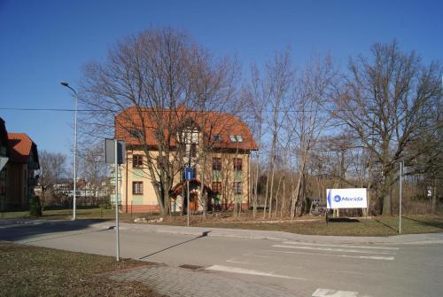 a building with a sign in front of a street at Przybobrze Apt. in Jelenia Góra