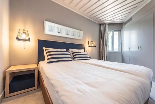 1 dormitorio con 1 cama grande y 2 almohadas de rayas en Hapimag Resort Porto Heli en Porto Heli