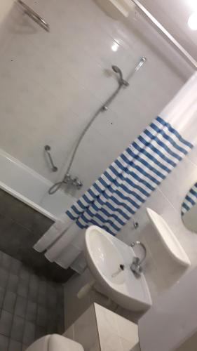 a bathroom with a sink and a toilet and a mirror at HELIOS, met Zonnig TERRAS, eigen KEUKEN, Verwarmd Binnen-ZWEMBAD, Nabij Dorp, Duinen, Strand en Vuurtoren in Hollum