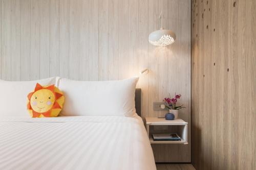 a bedroom with a white bed with a pillow at Village Hotel Sentosa by Far East Hospitality in Singapore