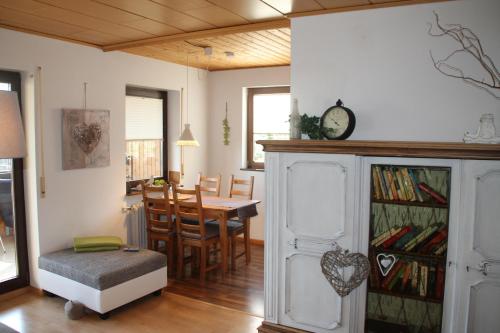 ein Wohnzimmer mit einem Tisch und einer Uhr an der Wand in der Unterkunft Ferienwohnung mit HERZ in Laufenburg in Laufenburg