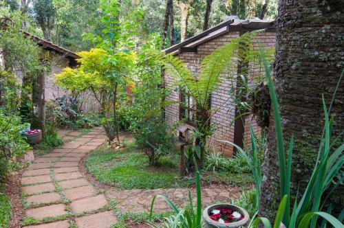 a garden with a stone walkway in front of a building at Estalagem Wiesbaden in Monte Verde