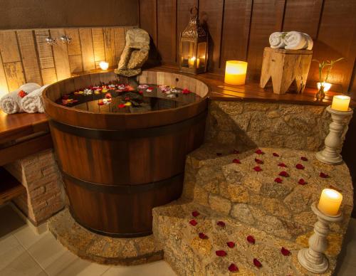 a bath tub with candles and roses in a room at Estalagem Wiesbaden in Monte Verde
