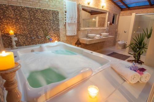 a bathroom with a bath tub with a sink at Estalagem Wiesbaden in Monte Verde