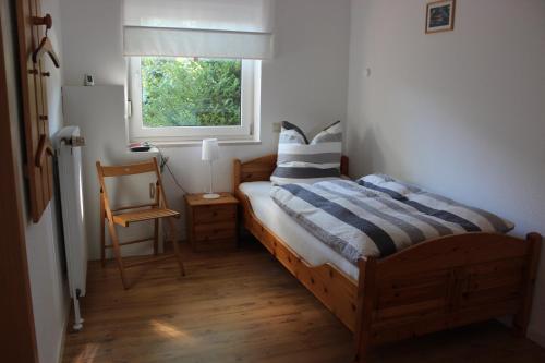 a bedroom with a bed and a window and a chair at Ferienwohnung Sannhoff in Schneverdingen