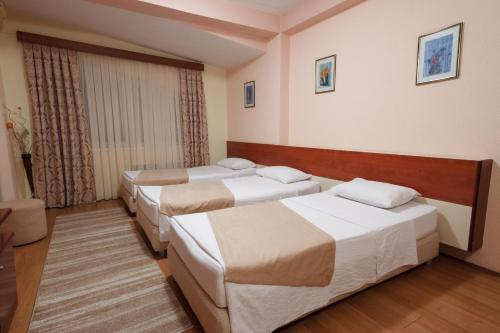 een rij van vier bedden in een hotelkamer bij Hotel Ilinden in Strumica