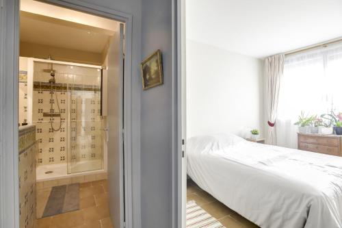 une chambre avec un lit et une douche à l'italienne dans l'établissement Charming apartment with terrace by Weekome, à Paris