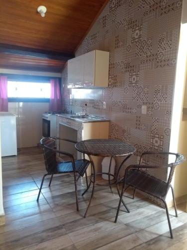 a kitchen with a table and two chairs and a counter at Tiradentes Pousada Ramalhete in Tiradentes