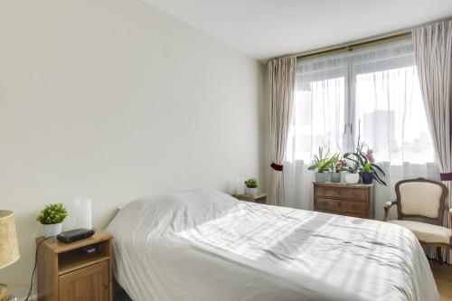 een slaapkamer met een wit bed en een raam bij Charming apartment with terrace by Weekome in Parijs