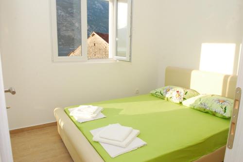 a bed in a room with a window at Hera Apartment in Donji Stoliv