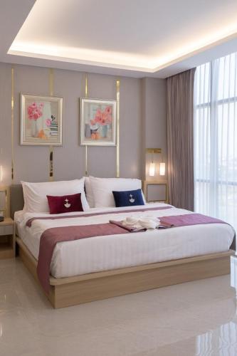 a large bedroom with a large bed with pillows at Elegant Airport Hotel in Bangkok
