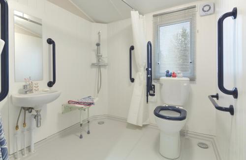 Un baño blanco con inodoro y lavabo. en Belle Aire Holiday Park, en Hemsby