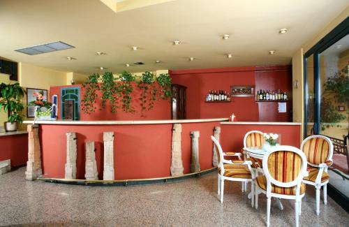 a restaurant with a red wall with a table and chairs at Hotel Nuovo Savi in Montecatini Terme