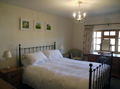 a bedroom with a large bed and a chandelier at One Pelham Grove Bed & Breakfast in Stocking Pelham