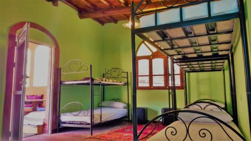 a room with two bunk beds and a mirror at Dounia Hostel in Tinerhir
