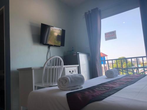a bedroom with a bed with a television and a balcony at Khao Oat airport in Nai Yang Beach