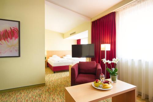 a hotel room with a table and a room at Welcome Hotel Paderborn in Paderborn
