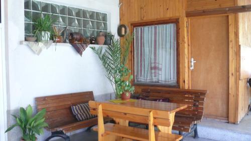 a porch with a wooden table and bench with potted plants at Villa Climate Guest House in Varna City