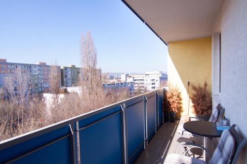 un balcón con una valla azul, mesas y sillas en After Six Apartment, en Bratislava