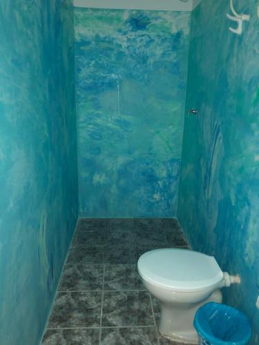 a bathroom with a toilet in a room with a fish mural at Pousada e Camping América in Morro de São Paulo