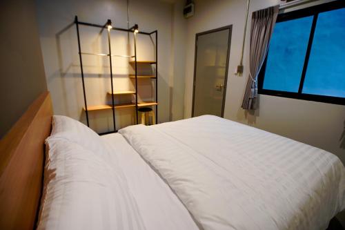 a bedroom with a white bed and a window at Bed garden 26 in Bangkok