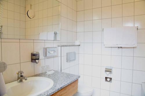 a bathroom with a sink and a toilet at Hotel Lonac in Duisburg