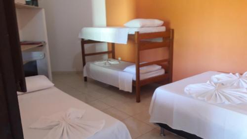 Habitación con 2 camas, sábanas blancas y toallas. en Cantinho dos Aquários, en Arraial d'Ajuda