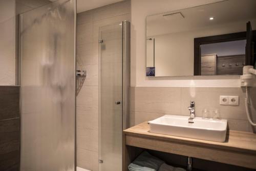 a bathroom with a sink and a shower at Hotel am Hof in Sölden