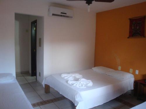 1 dormitorio con 1 cama con toallas en Cantinho dos Aquários, en Arraial d'Ajuda
