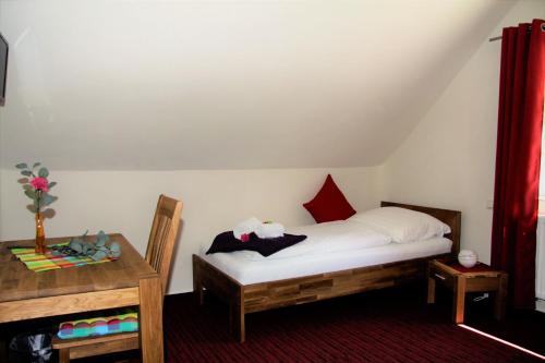 a small bedroom with a bed and a table at Alter Fritz Erfurt in Erfurt