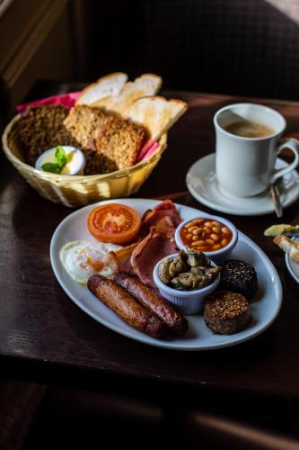 a table with a plate of breakfast food and a cup of coffee at The Horse and Hound Hotel in Ballynabola