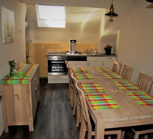 eine Küche mit einem langen Holztisch mit Stühlen in der Unterkunft Alter Fritz Erfurt in Erfurt