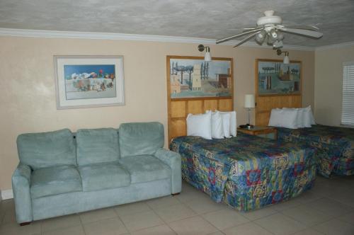 a hotel room with a couch and a bed at Sea Vista Motel in New Smyrna Beach