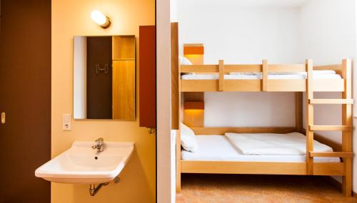two bunk beds and a sink in a bathroom at Jugendherberge Garmisch-Partenkirchen - membership required! in Garmisch-Partenkirchen