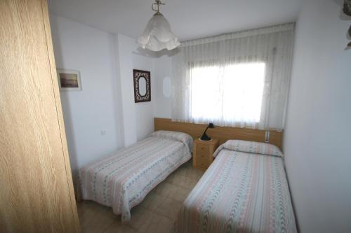 een slaapkamer met 2 aparte bedden en een raam bij Apartamento Bahia Dorada in Cambrils