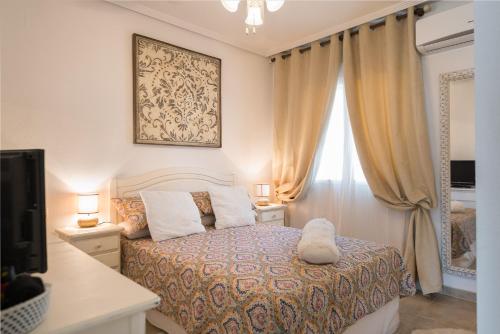 エル・カンページョにあるBeach House - healthy, protected location! El Campello, Alicante Spainのベッドルーム1室(ベッド1台、ランプ2つ、窓付)