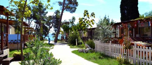 a white fence in front of a yard with flowers at Dream Apartments in Split