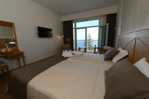 a hotel room with a large bed with a large window at Hotel Do Campo in Ribeira Brava
