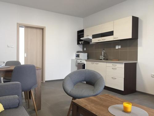 ein Wohnzimmer mit einem blauen Stuhl und eine Küche in der Unterkunft Apartmány Miromar in Podivín