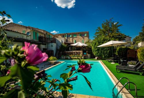 une piscine dans une cour fleurie dans l'établissement LOGIS HOTEL L' Auberge d'Uzes, à Uzès