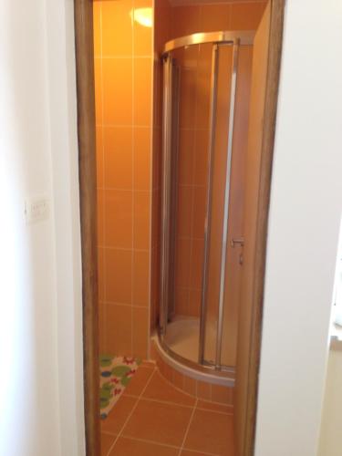 a shower in a bathroom with orange tile at Novalja City Central Apartments in Novalja