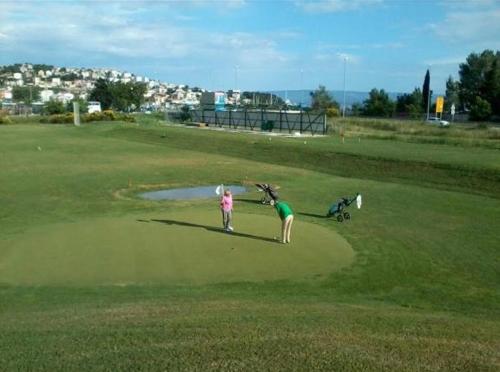 a couple of people standing on a golf course at Dream Apartments in Split