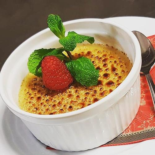 a bowl of cereal with strawberries and mint on a plate at Parkhotel Meerane in Meerane