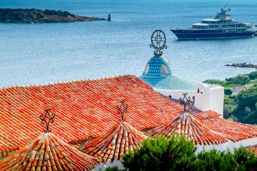a cruise ship in the water next to a building at Antica Dimora La Corona in San Pantaleo