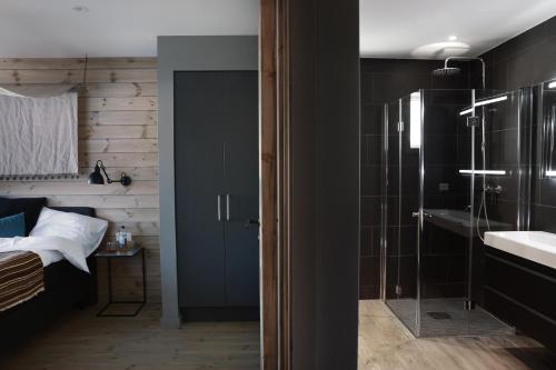 a bathroom with a glass shower and a sink at Solsiden Brygge Rorbuer in Ballstad