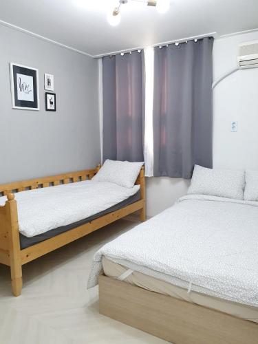 a bedroom with two beds and a window at Y.ROAD 135 in Seoul