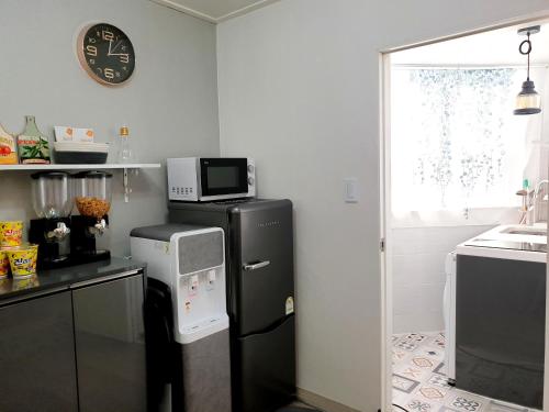 a kitchen with a black refrigerator and a microwave at Y.ROAD 135 in Seoul